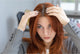Woman with red hair inspecting her scalp