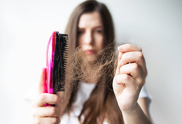 Woman pulling her hair out of a comb.